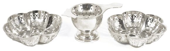 A pair of silver pierced bon bon dishes and a silver tea strainer,the hexagonal lobed pierced bon