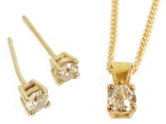 A small contemporary diamond set pendant and matching diamond ear studs,the yellow metal pendant,