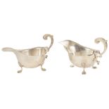 A pair of Mappin & Webb silver sauce boats with scrolled handles, upon shell and paw supports,
