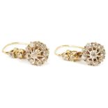 A pair of diamond set daisy cluster drop earrings, circa 1940having raised spoke set central diamond