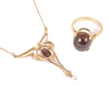 An Edwardian Arts & Crafts rose gold garnet and pearl pendant necklacethe 9ct gold scroll pendant