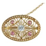 A delicate Edwardian 15ct. gold seed pearl and gem set scroll brooch,the oval brooch set with four