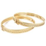 A pair of contemporary matching 9ct gold hinged bangles each with a continual central raised Greek
