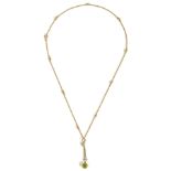 A delicate Edwardian peridot set gold drop pendant on fancy chainthe pendant marked 9ct and with