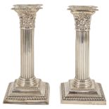 A pair of silver dwarf candlesticks, Birmingham 1908with beaded concave drip trays above