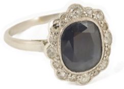 An attractive Edwardian sapphire and diamond cluster ringthe dark blue sapphire mounted in a