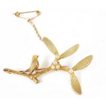 A charming Edwardian 15ct three colour gold 'bird on a mistletoe branch' broochby Henry Griffith &