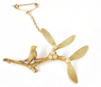 A charming Edwardian 15ct three colour gold 'bird on a mistletoe branch' broochby Henry Griffith &