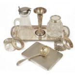 A collection of silver, napkin rings, cigarette case, bud vase, glass inkwell and jug