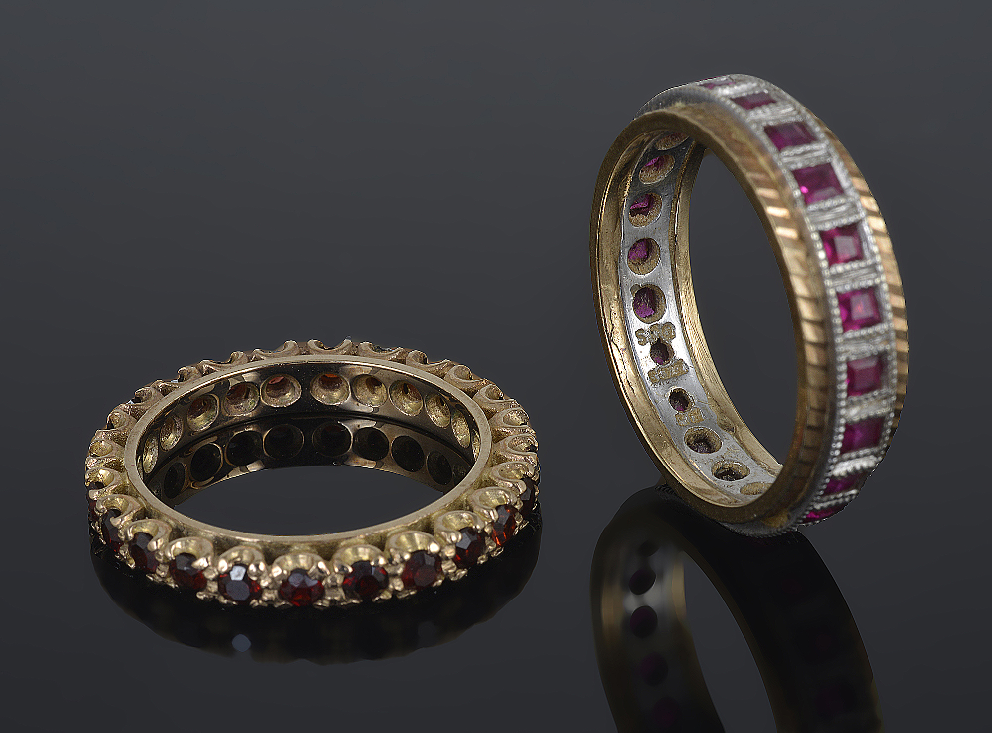 A square ruby set full eternity ring and a garnet set eternity ring