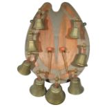 An unusual set of eight brass turned bells on horseshoe backboard
