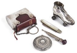 A collection of novelty silver, roller skate pin cushion, fruit knife, prayer book holder, compact,