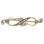 A delicate diamond set ribbon scroll brooch, circa 1900