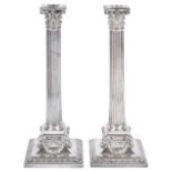 A pair of Elkington & Co silver plated candlestickseach with canted drip trays, with corinthian