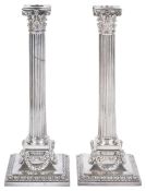 A pair of Elkington & Co silver plated candlestickseach with canted drip trays, with corinthian