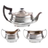 An Edwardian three piece tea service, hallmarked Sheffield 1918the teapot with ribbed body and