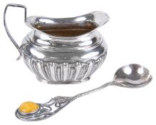 A Polish Baltic amber silver spoon and a Victorian silver cream jugthe spoon with trailing leaves