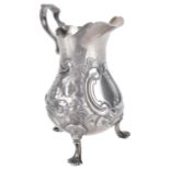 A Victorian silver cream jug, hallmarked London 1843the scalloped rim with scroll handle on a