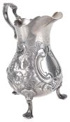 A Victorian silver cream jug, hallmarked London 1843the scalloped rim with scroll handle on a