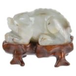 An early 20th century carved jade figure of a boarthe crouched mammal on a carved hardwood fitted