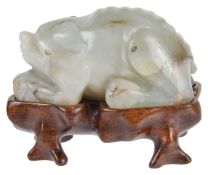 An early 20th century carved jade figure of a boarthe crouched mammal on a carved hardwood fitted