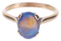 A single stone precious black opal set ringthe oval opal mounted in a yellow metal mount, tests