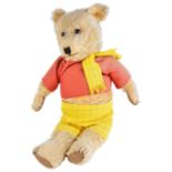 A vintage Rupert teddy bear dressed in a red top, with yellow and black checkered trousers and