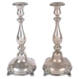 A pair of Continental silver plated candlesticksthe foliate embossed drip trays above baluster