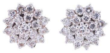 A pair of contemporary diamond set cluster earringshaving central diamond surrounded by two rows