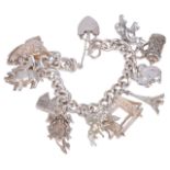 A heavy silver curb link charm braceletthe bracelet hung with a variety of charms including an