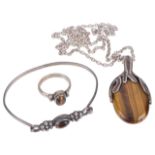 Three pieces of modernist silver and tigers eye jewellerycomprising an oval pendant on chain, a