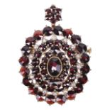 A Victorian style garnet and seed pearl oval cluster pendant broochthe hanging loop hinged and set