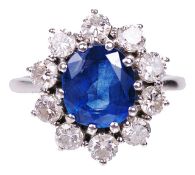 An attractive contemporary sapphire and diamond set cluster ringthe oval sapphire set within a