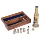A mid 19th century brass drum microscope in fitted casewith two objectives, lenses and five specimen