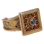 An unusual Continental sapphire and enamel ringhaving central small claw set sapphire within red and