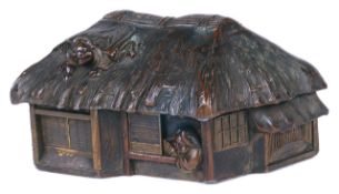 A Meji period Japanese bronze model of a house realistically modelled with thatched roof and figures