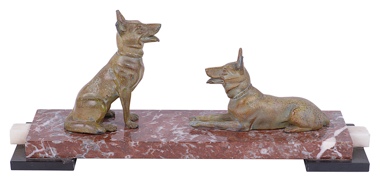 An Art Deco style mantelpiece a pair of spelter dogs one seated and the other lying upon a stepped