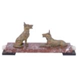 An Art Deco style mantelpiece a pair of spelter dogs one seated and the other lying upon a stepped