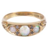 An Edwardian 18ct gold three stone opal set ringthe opals in scroll mount and with diamond point