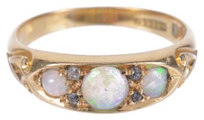 An Edwardian 18ct gold three stone opal set ringthe opals in scroll mount and with diamond point