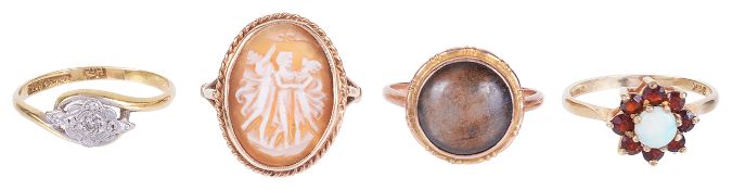 A gold mounted carved shell cameo ring and three other gold ringsthe oval cameo carved as 'The Three