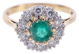 An emerald and diamond set daisy cluster ringthe central circular emerald of good colour and set