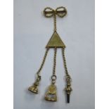 GOLD COLOURED CHATELAINE WITH TWO SEAL STAMPS AND WATCH WINDER ON BOW BROOCH