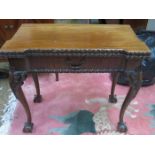 CARVED ANTIQUE MAHOGANY FOLD OVER GAMES TABLE ON BALL AND CLAW SUPPORT WITH FELT LINED INTERIOR AND