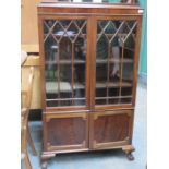 MAHOGANY TWO DOOR GLAZED DISPLAY CABINET ON BALL AND CLAW SUPPORTS