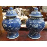 PAIR OF ORIENTAL STYLE BLUE AND WHITE PRUNUS PATTERN STORAGE JARS WITH COVERS