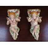 PAIR OF CONTINENTAL HANDPAINTED AND GILDED RELIEF DECORATED CHERUB FORM WALL POCKETS