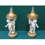 PAIR OF DECORATIVE FIGURE FORM CANDLE STANDS WITH COVERS,