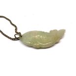 A carved jade fish amulet on a sterling silver chain.