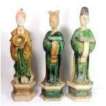 Three Chinese Tang dynasty glazed terracotta attendant figures with detachable heads, H. 47cm.